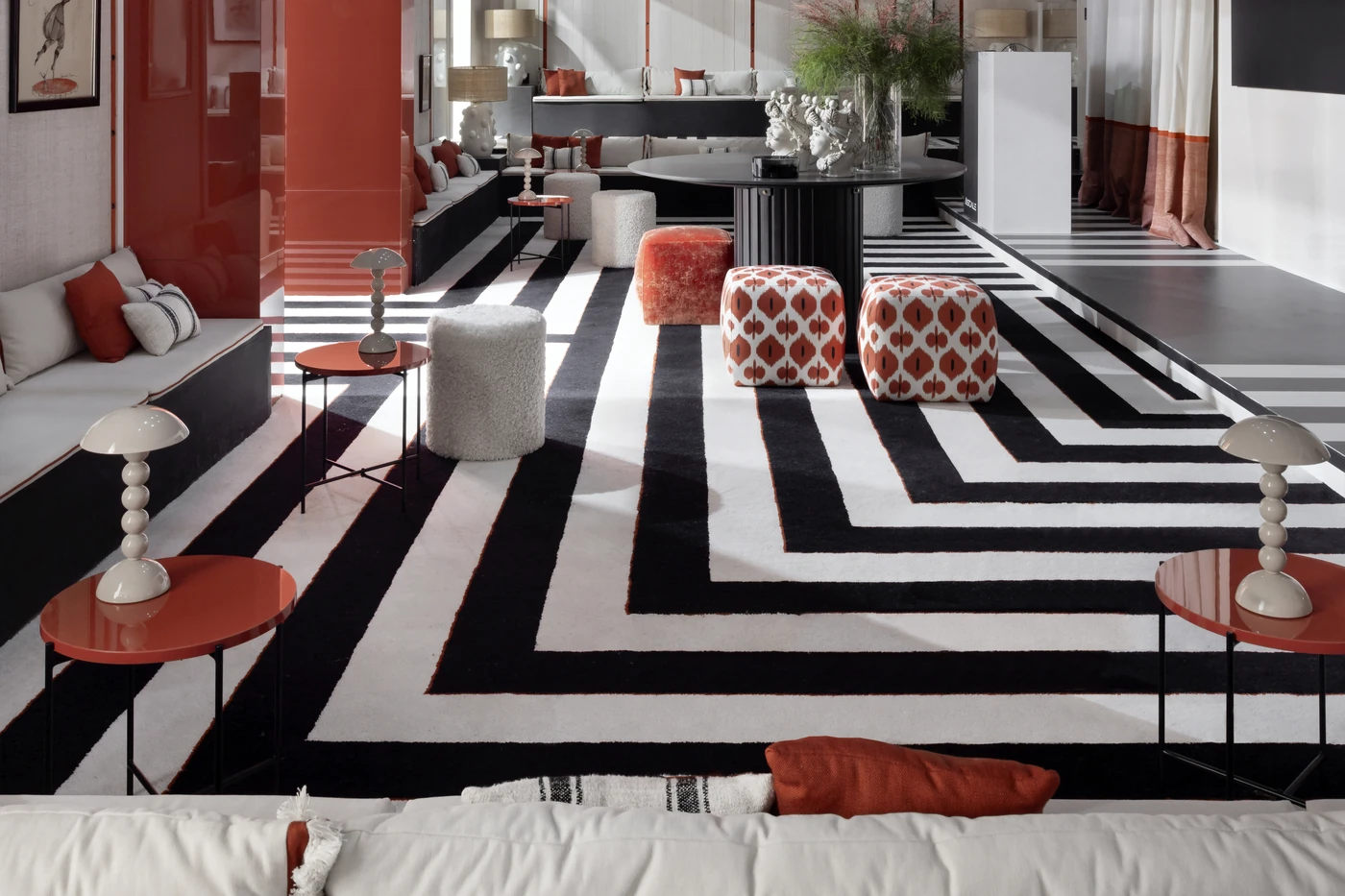 Gran alfombra geométrica negra y blanca integrada en un salón.