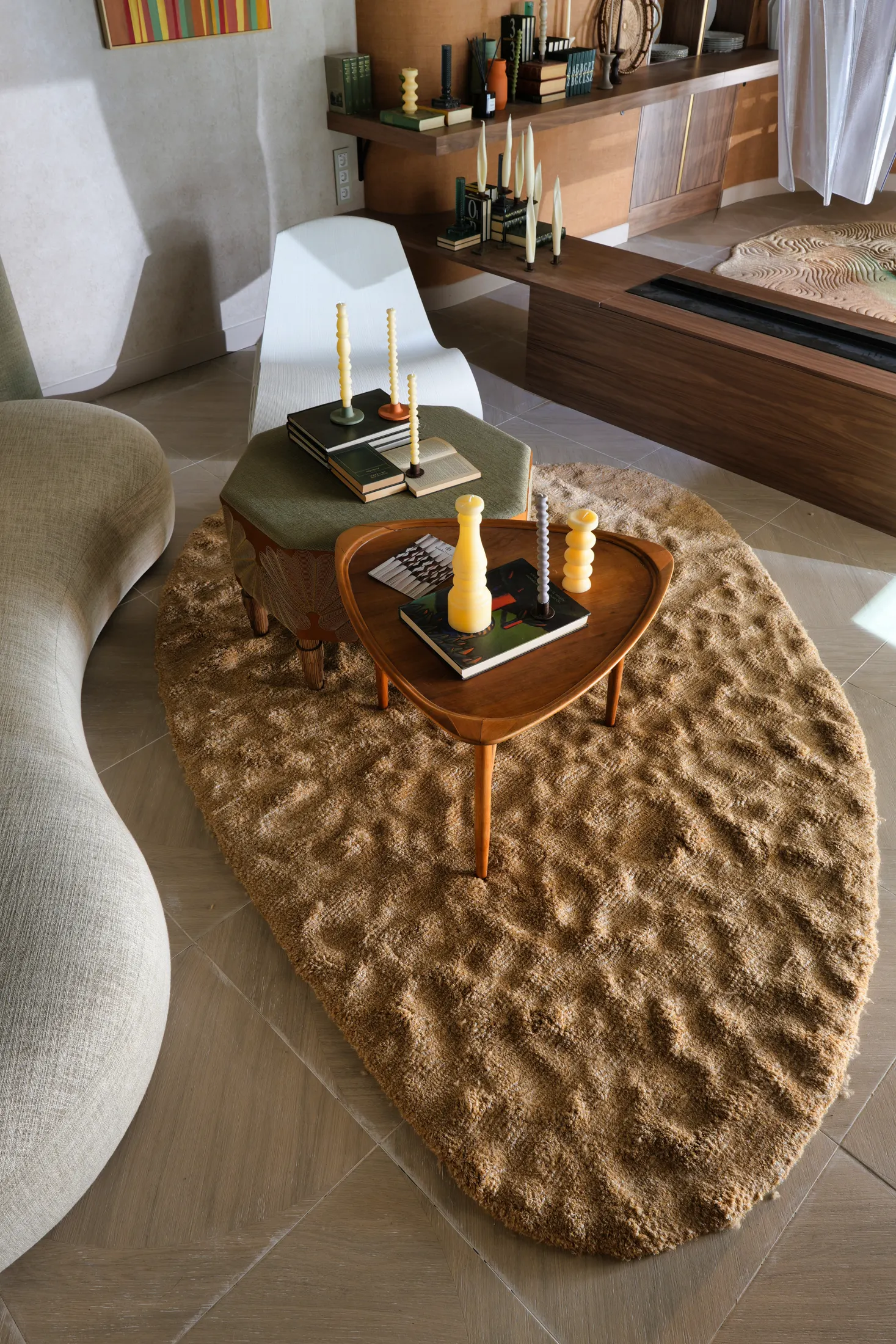 Salón con sofá blanco curvo y alfombra Filomaestro de pelo alto en marrón